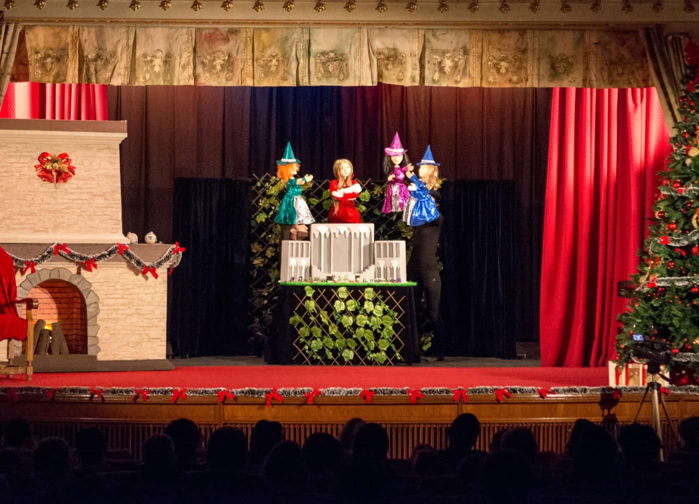Moș Crăciun și elfii pe scenă, spectacol de Crăciun pentru copii, decor festiv.