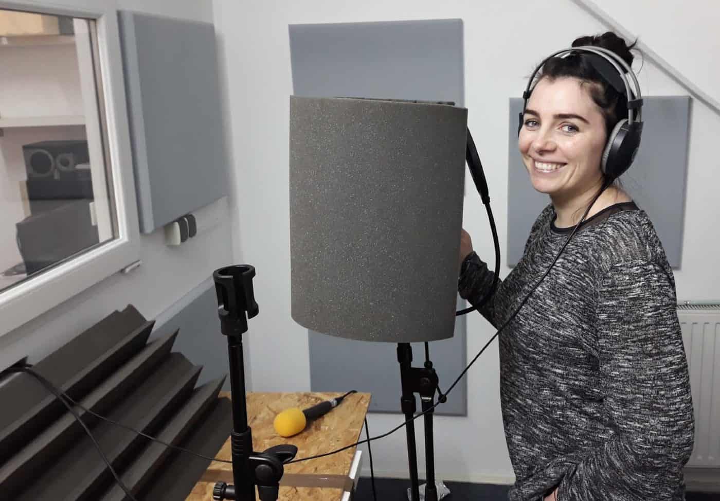 Înregistrare vocală în studio cu microfon și căști pentru podcast sau voice-over.