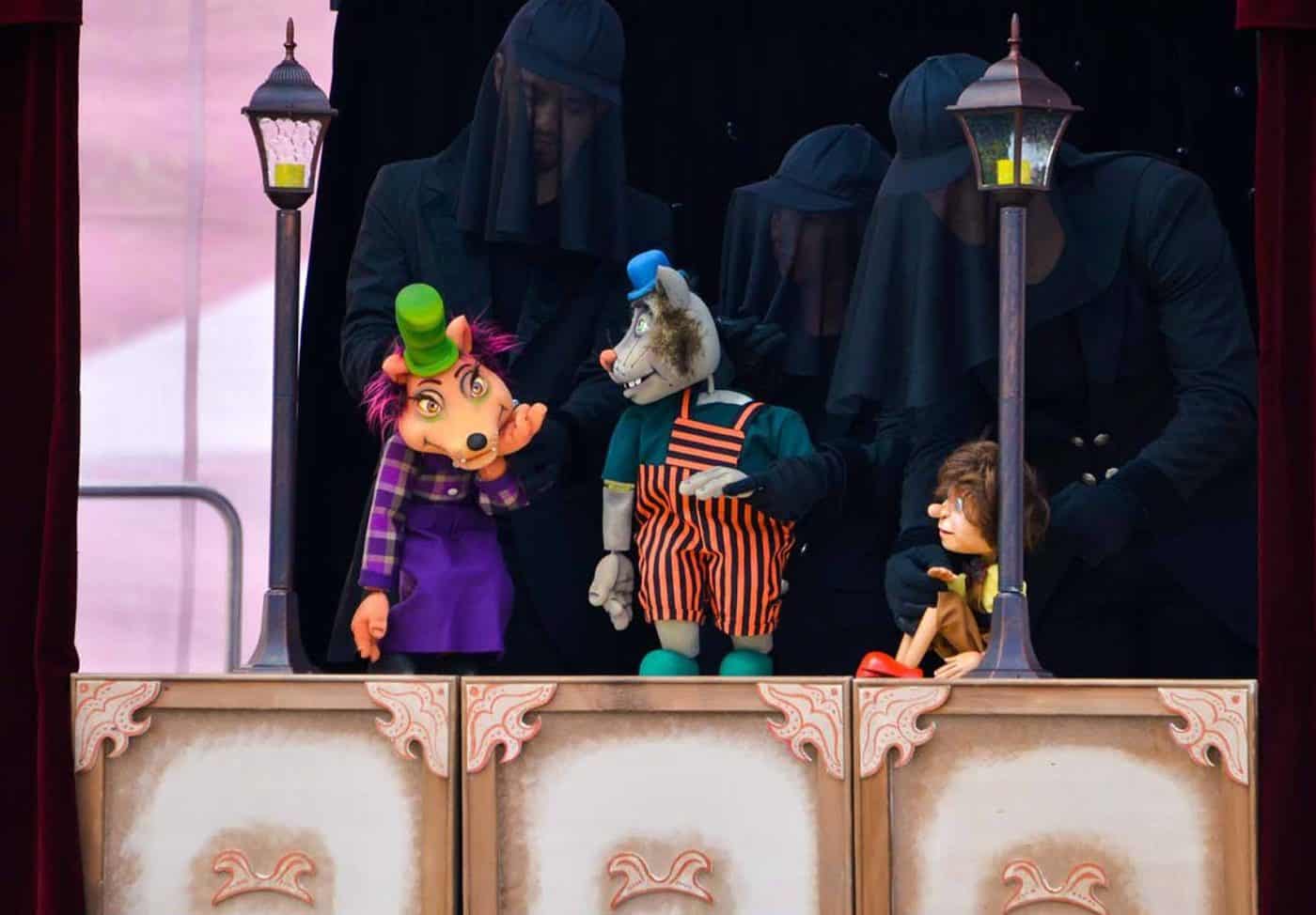 Personaje cu mască de lup și personaje mascate pe scenă, spectacol pentru copii.