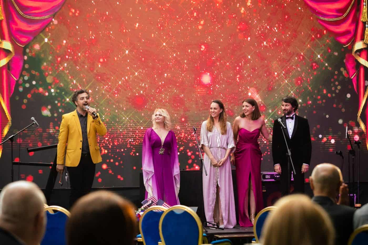Creas - Eveniment artistic cu artiști pe scenă și public în sală, atmosferă elegantă.